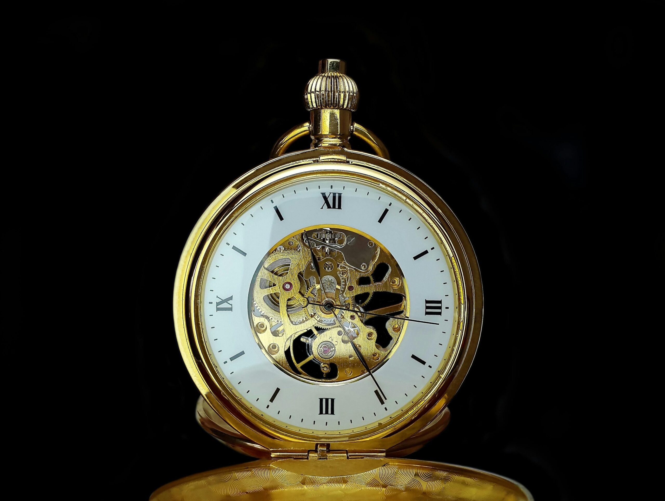 A close-up of a gold-toned watch against autumn leaves