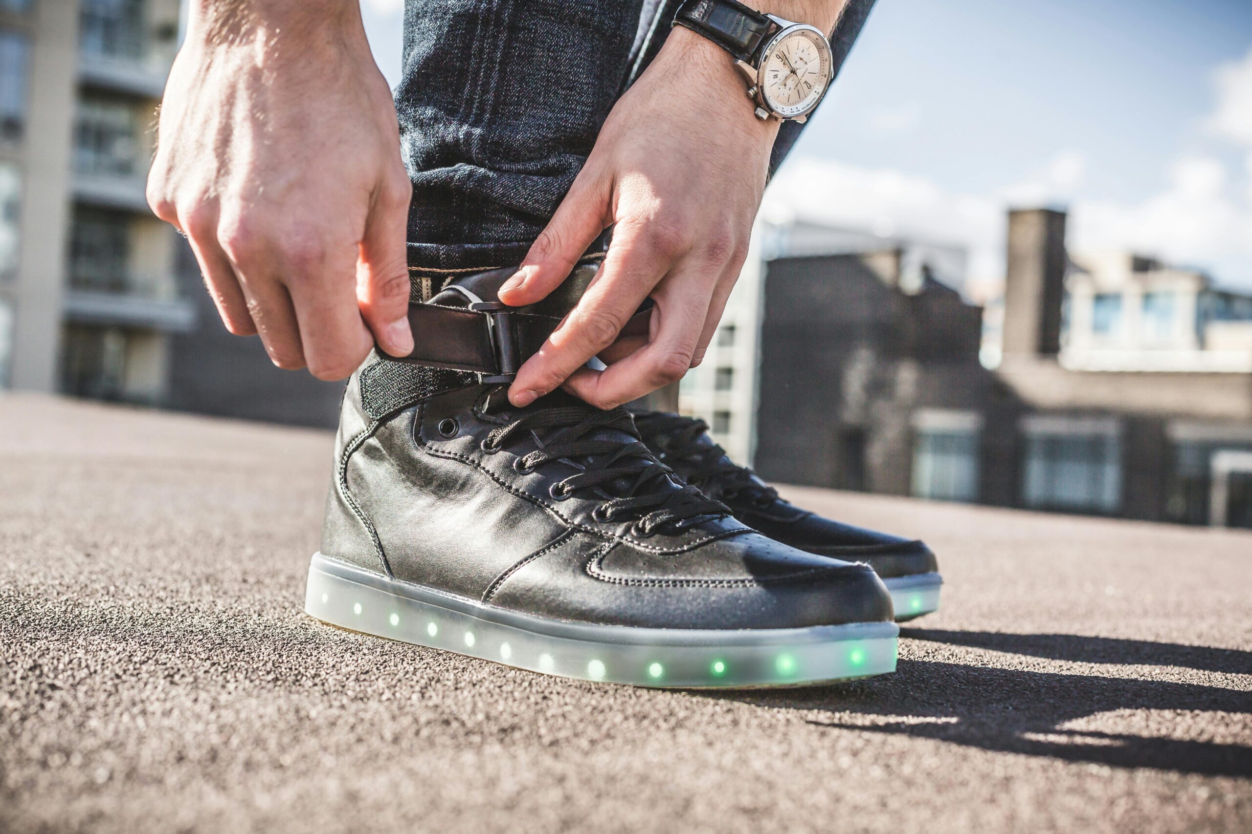A futuristic-looking watch with a neon green bezel worn with casual streetwear
