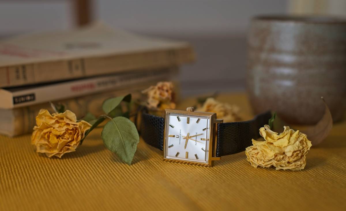 A close-up of elegant spring floral watches displayed against a soft pink background.