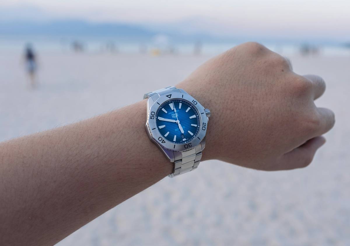 A tray of colorful watches in pastel shades displayed on a white marble table