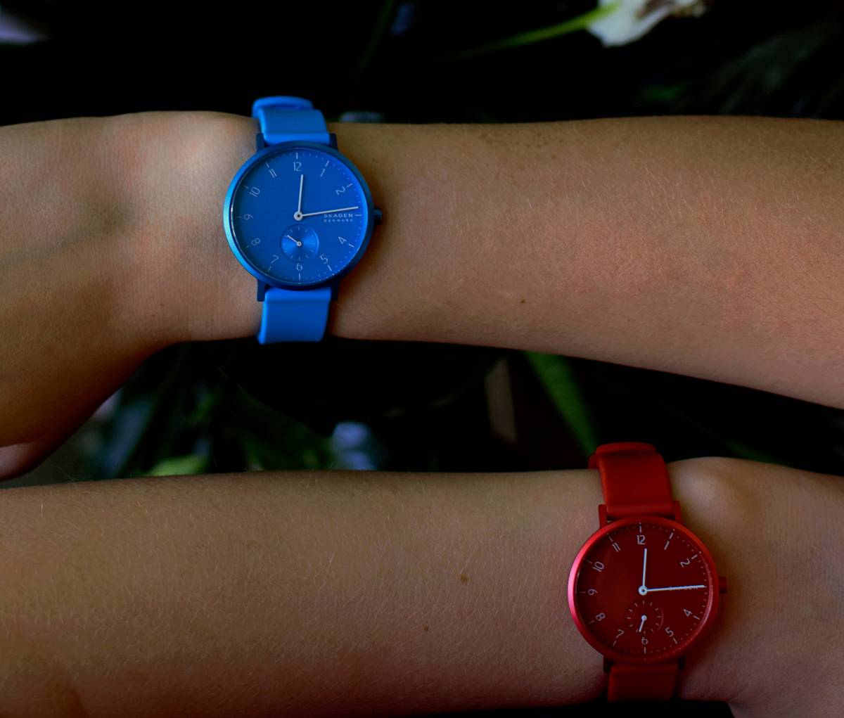 A close-up shot showcasing various avant-garde colored watches displayed on a sleek wooden table.